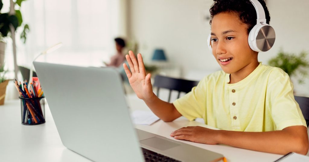 Niño aprendiendo verbos con la mano levantada