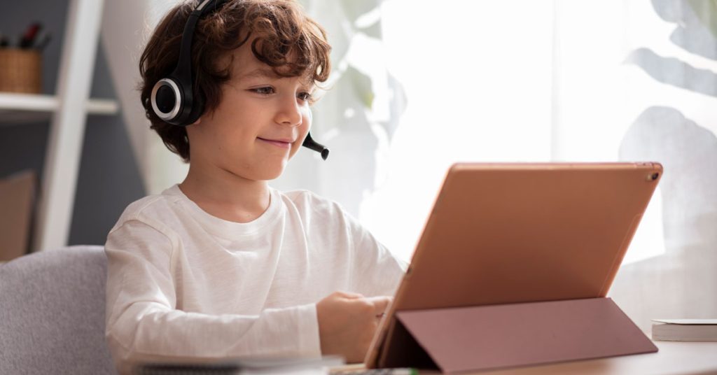 Niño usando tablet para aprender verbos en inglés